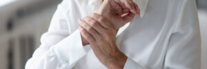 Aging woman grabbing achy wrist from arthritis