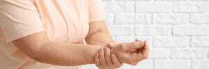 Senior woman suffering from Parkinson syndrome on white background