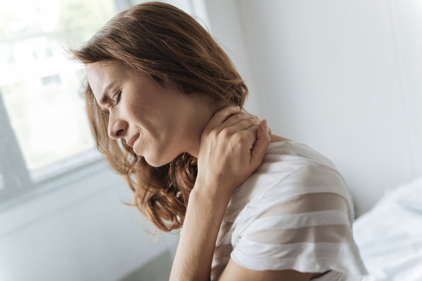 Woman grabbing neck in pain from fibromyalgia