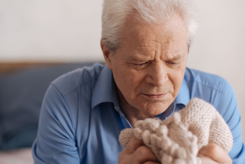 Elderly man with dementia holding blanket