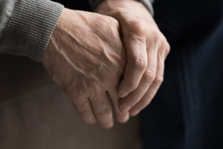 Man clenching hands as he deals with early signs he might have Parkinson's Disease